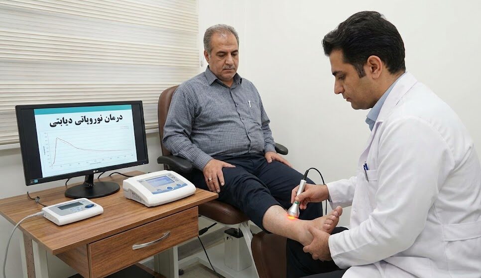 پزشک در حال انجام لیزر تراپی کمتوان روی پای بیمار دیابتی به عنوان یک روش نوین درمان زخم و نوروپاتی.
